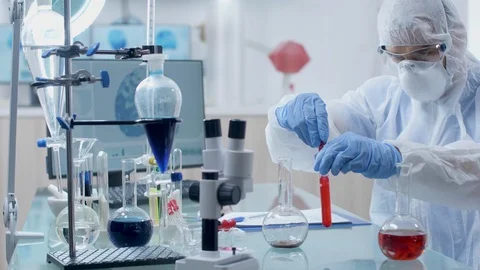 Concentrated researcher taking samples from a red liquid Stock Footage 108741021