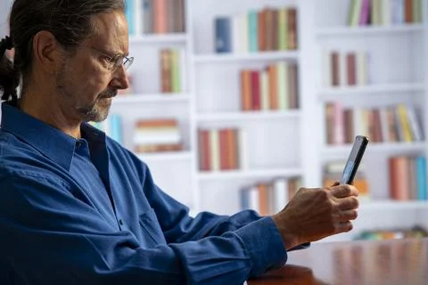 Concentrated serious mature man working with phone. 스톡 사진