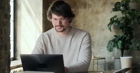Concentrated serious young man working from home and enjoying distant job. Stock Footage 156870767