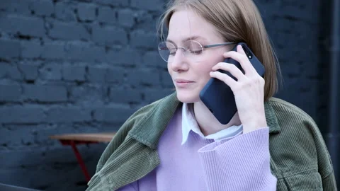 Concentrated short haired lady talks on black smartphone Video stock 156777024