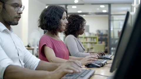 Concentrated students passing exams by computers in class Stock Footage 116775663