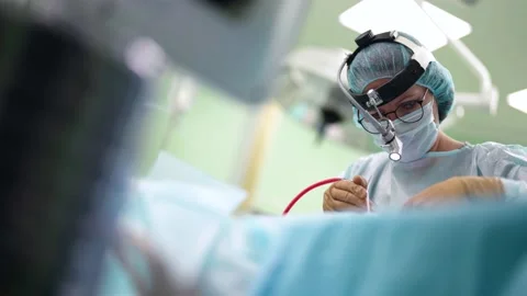 Concentrated surgeon is working in operating room, woman is wearing sterile Stock Footage 167112406