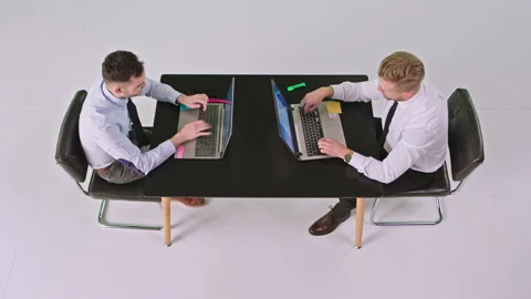 Concentrated two office workers men sitting at the same tablet in front of each Stock Footage 131562115