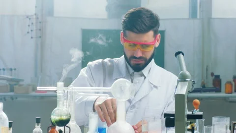Concentrated upset scientist student doing some experiments in the chemistry Stock Footage 159809772