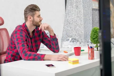 Concentrated on work. Concentrated young beard man working on laptop while Stock Photos