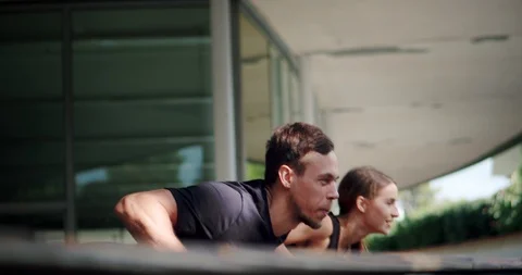 Concentrated young Caucasian active couple doing push-ups energetic together Stock Footage 123661390