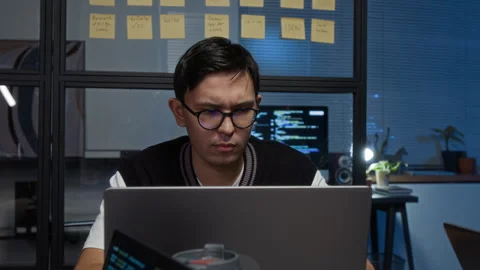 Concentrated Young IT Specialist Creating Software App in front of Laptop Screen Stock Footage 329613363