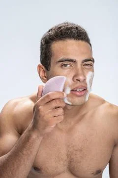 Concentrated young man carefully wasing his face Stock Photos