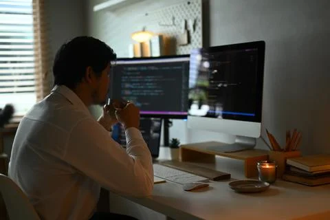 Concentrated young professionals working in software development in dark office Stock Photos