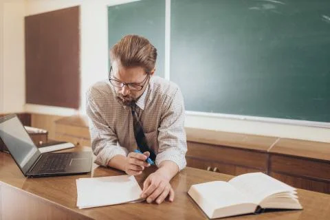 Concentrated Young Professor Checking Students' Test Papers Stock Photos