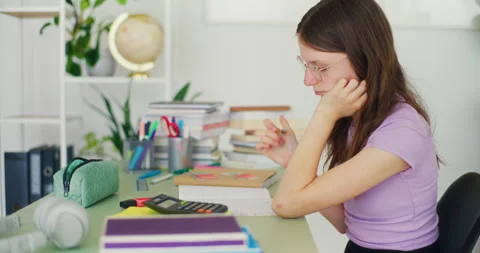 Concentrated Young Student Doing Homework and Studying at Her Desk Stock Footage 277136402