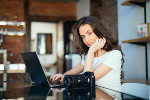 Concentrated young woman watching tutorial online on modern laptop device usi Stock Photos