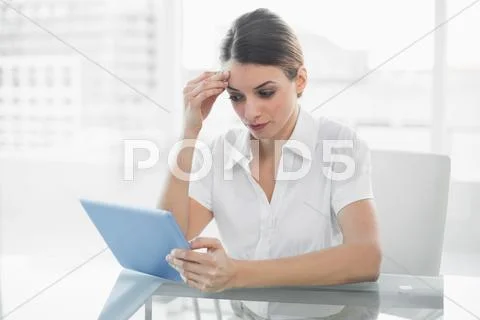 Concentrating brunette businesswoman working with her tablet Stock Photos