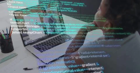 Concentrating man coding on laptop at desk, with code overlay, pencils cable Stock Photos
