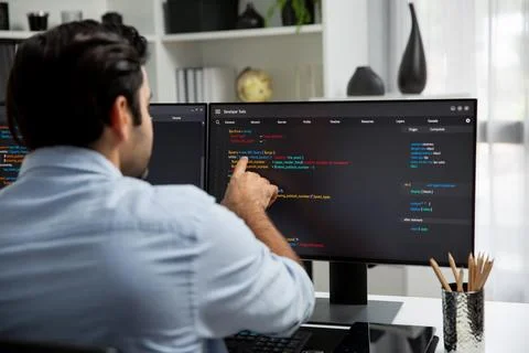 Concentrating in smart IT developer working coding on two pc screen. Surmise. Foto stock