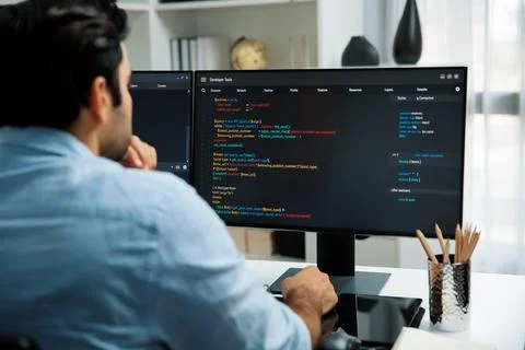 Concentrating in smart IT developer working coding on two pc screen. Surmise. Stock Photos