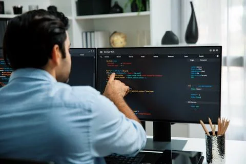 Concentrating in smart IT developer working coding on two pc screen. Surmise. Foto stock