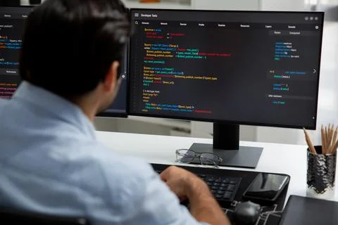 Concentrating in smart IT developer working coding on two pc screen. Surmise. Stock Photos