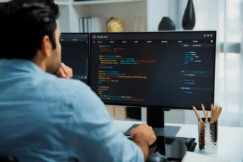 Concentrating in smart IT developer working coding on two pc screen. Surmise. Stock Photos