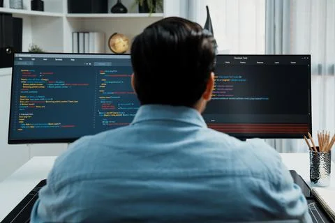 Concentrating in smart IT developer working coding on two pc screen. Surmise. Stock Photos