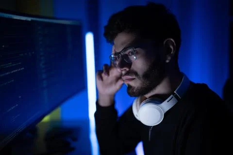 Concentration and creativity during late-night coding session in a modern w.. Stock Photos