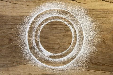 Concentric circles made with powdered sugar or white flour on a oak wooden .. Stock Photos