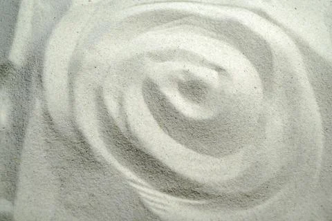 Concentric circular patterns raked into fine light grey sand, evoking a zen.. Stock Photos