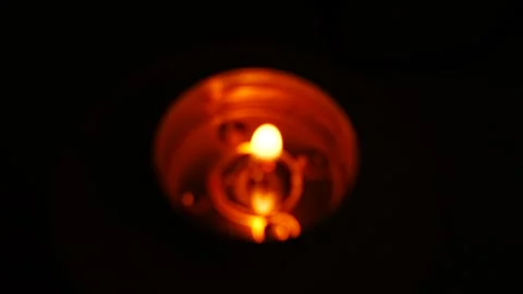 Concentric rings of reflected candle light glowing around a blurred flame in the Stock Footage 347446382