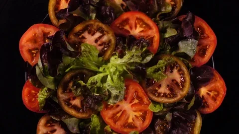Concentric top view of fresh red and green tomatoes slices, put on black dish Video stock 78349797
