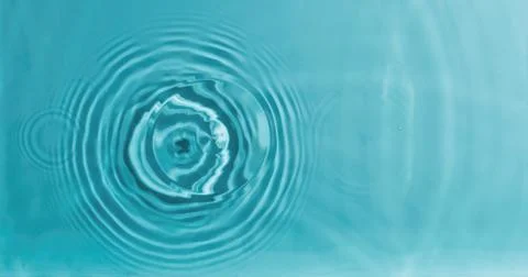 Concentric water waves interference pattern on turquoise fluid surface Stock Photos