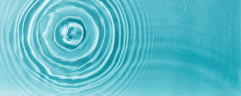 Concentric water waves interference pattern on turquoise fluid surface Stock Photos
