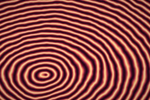 Concentric wavy circles in warm red and cream tones provide a psychedelic r.. Stock Illustration