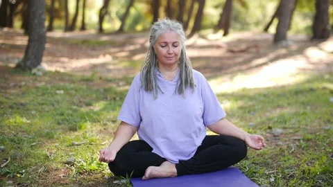 Concept of active life in middle age. Mature healthy woman with gray hair doing Stock Footage 220369160