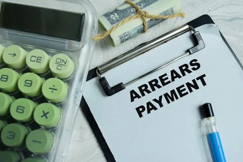 Concept of arrears payment write on clipboard isolated on Wooden Table. 스톡 사진