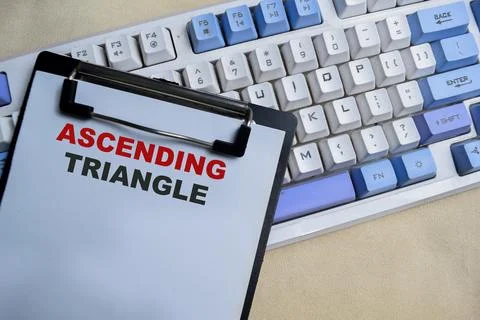 Concept of Ascending triangle write on clipboard isolated on Wooden Table. Fotos de archivo
