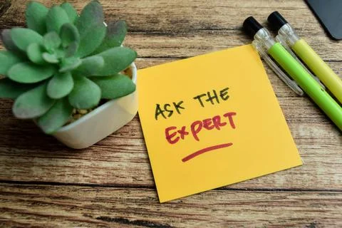 Concept of Ask The Expert write on sticky notes isolated on Wooden Table. Stock Photos