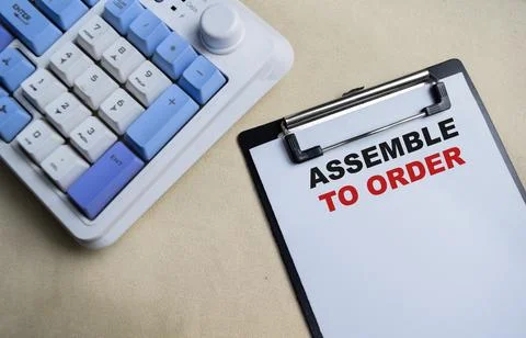 Concept of Assemble to order write on clipboard isolated on Wooden Table. Stock Photos