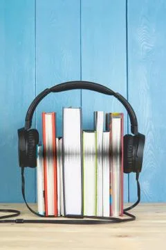 Concept of audio book. headphone and books on blue background Stock Photos
