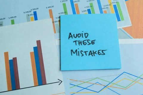 Concept of Avoid These Mistakes write on sticky notes isolated on Wooden Table 写真素材