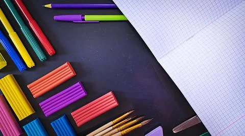 Concept back to school, school supplies on black chalkboard with an open Stock Photos