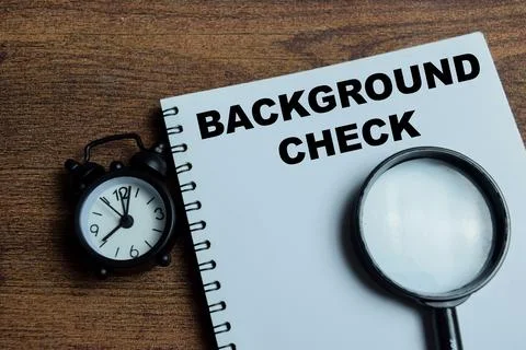 Concept of background check write on book isolated on Wooden Table. Stock Photos