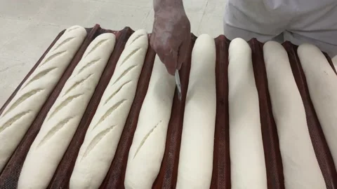 Concept baker, bread, artisan. Baker making bread and cutting the dough. Stock Footage 164144033