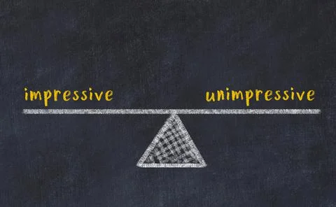 Concept of balance between impressive and unimpressive. Black chalboard with  写真素材
