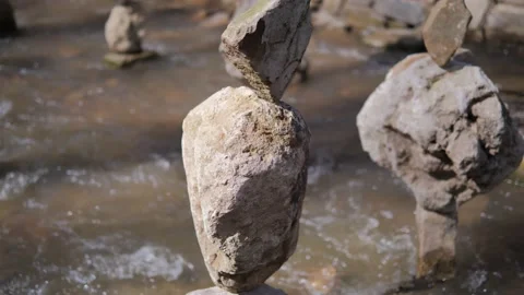 The concept of balance. A stone balances on another stone on mountain river Stock Footage 169041863