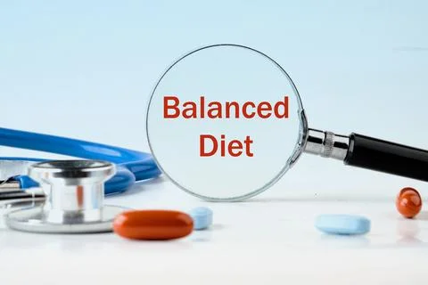 Concept Balanced Diet. text written through a magnifying glass on a light blu Stock Photos