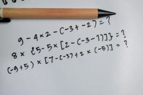 Concept of basic math operation write on book isolated on Wooden Table. Stock Photos