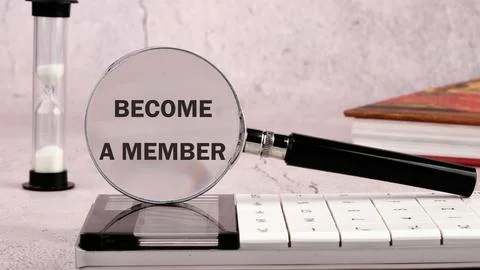 Concept. Become a member text through a magnifying glass on a gray wall, fron Stock Photos