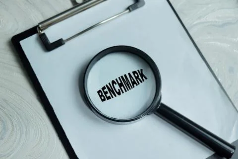 Concept of benchmark write on clipboard isolated on Wooden Table. Stock Photos