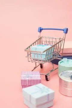 Concept black friday, gift boxes with shopping cart on pink pastel background Stock Photos