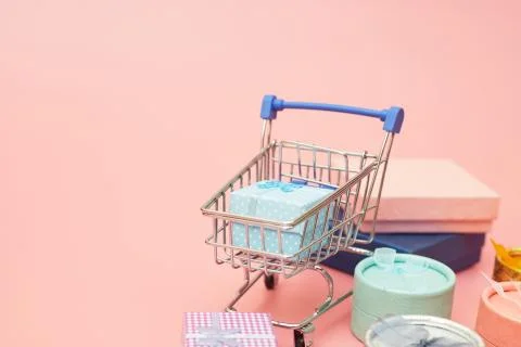Concept black friday, gift boxes with shopping cart on pink pastel background Stock Photos